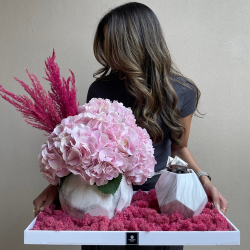 Hue of pink - An arrangement of hydrangeas in marble vases with chocolates in a white tray L 40cm*Flower kind and color may slightly
differ based on availability.