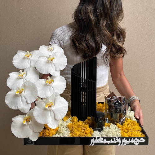 Mubkhar IIII - An arrangement of orchids with Modern Mubkhar, 3 tulles of mamoul and chocolates*Flower kind and color may slightly
differ based on availability.