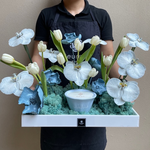 Baby breath - An arrangements of flowers with customized Shamaa candle in a white tray *Write the desired name on the candle in the message box *Flower’s color and kind may slightly differ based on availability