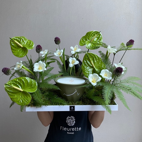 Tropical garden - An arrangement of flowers with 21cm Shamaa candle in a big white tray. *write the desired name in the message box. * Flower color and kind may slightly differ based on availability.