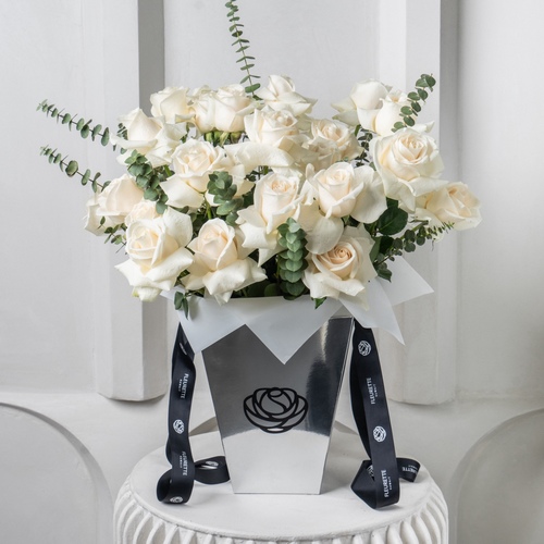 Pure White - Roses and eucalyptus beautifully arranged in our medium signature metallic bag