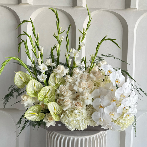 Pure white garden - An arrangement of hydrangeas, gladiolus, roses, anthuriums and orchids in a long cement vase *Flower colors and kind may slightly differ based on availability