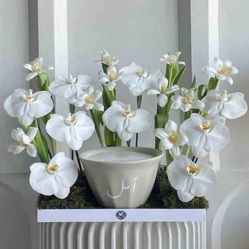 Pure in white - An arrangement of flowers with 21cm Shamaa candle *Write the desired name on the candle in the message box L 40cm*Flower kind and color may slightly 
differ based on availability.