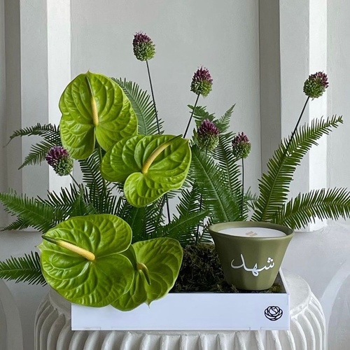 Tropical dream - An arrangement of flowers with 12cm Shamaa candle *write the desired name on the candle L 30cm *Flower kind and color may slightly differ based on availability