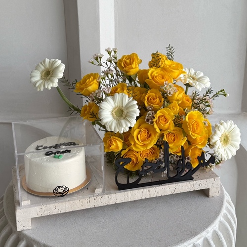 Sunkissed Cake - A tray that contains roses, gerberas and wax flowers along with a cake .
 *write the desired name in the message box *Flowers color and kind may slightly differ based on availability  
 L 40   H 25