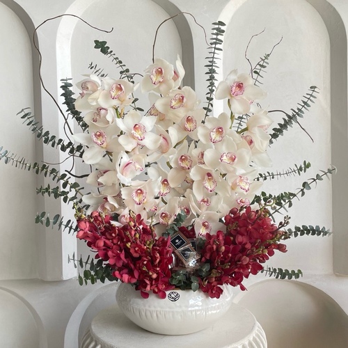 Life in Bloom - Arrangement of cymbediums and red mokara with chocolates in a ceramic white vase 
 L 30cm * H 65cm*Flower kind and color may slightly
differ based on availability.