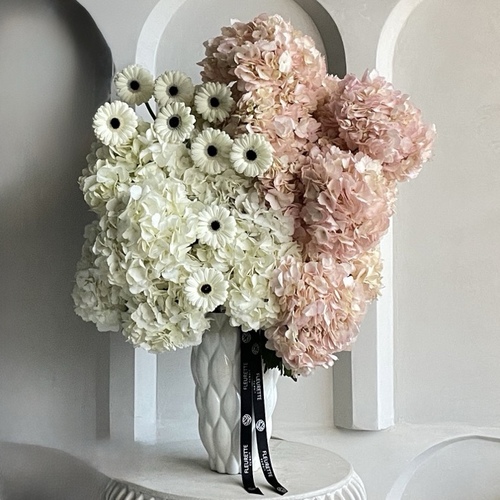 Powder pink clouds - An arrangement of hydrangeas and gerberas in a tall white vase *Flowers color and kind may slightly differ based on availability