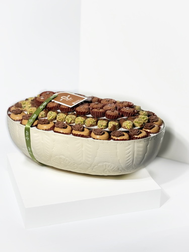 Oval tripar chocolate - Triber” Luxury Tray – Filled Chocolate Assortment 620g of handcrafted chocolates with premium fillings: Dulce Lotus, Crispy Pistachio, and Round Crispy Elegantly arranged in a textured ceramic dish — perfect for gifting or celebrations.
