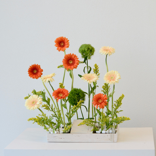 sunset daisy - A travertine tray that gerbera flowers with hazelnut truffle chocolates.