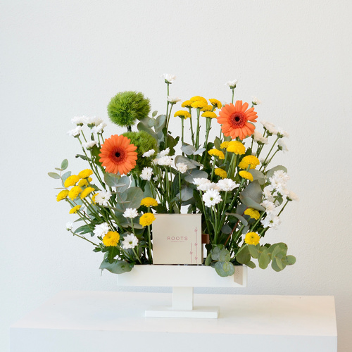 Sunshine Daisy - A wooden tray that contains chrysanthemum and gerbera flowers with hazelnut truffle chocolates.