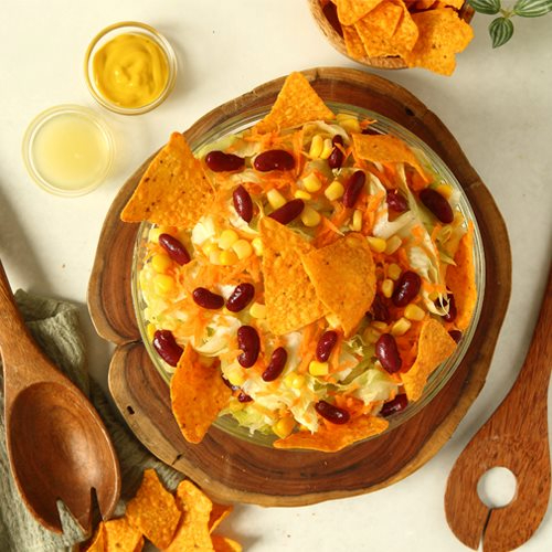 Nachos Salad - lettuce, shredded carrots , red beans and corn topped with Nachos chips