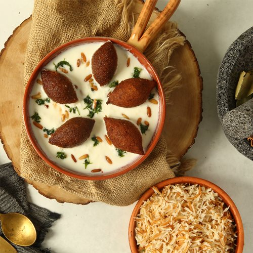 Kibbeh b Labban - fried kibbeh with garlic yogurt sauce served withwhite vermiceli rice