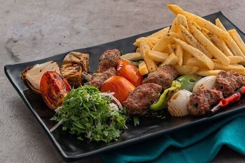 Lokmat Beit - Kabab orfali - KAbab , tomato , grilled onion & pepper served with biwaz & fries