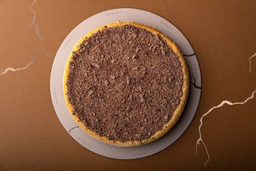 Chocolate cheesecake - A buttery crust paired with a creamy cheese layer covered with chocolate shavings and served with a warm rich velvety