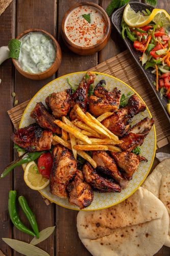 Grilled Chicken - 6 Pieces of carefully Marinated Chicken Grilled on Charcoal on a special Tabliah way served with Fries , Bread , Garlic Sauce , and Mixed Pickles