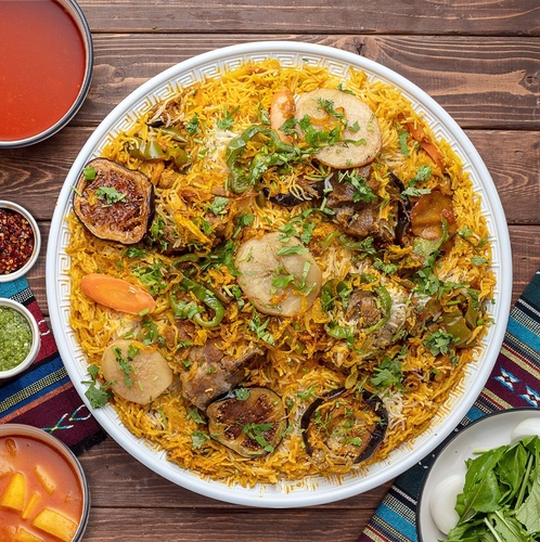 Meat Maklouba - Basmati bread with the addition of spices and saffron, meat is added to it, served with potato broth or tomato daqoos, two kinds of maabouj, onion and watercress box