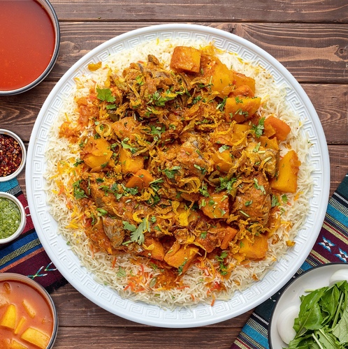 Meat Biryani - Basmati bread cooked with meat broth, cooked to the softness of the people of the land, in addition to the fresh Kuwaiti meat, served with potato broth or daqoos, two types of maabouj, a box of arugula and onions