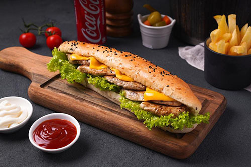 Chicken steak - Slices of grilled chicken inside a french bun with lettuce, cheese and mayonnaise