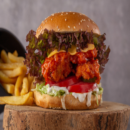 Spicy Buffalo Burger - Buffalo chicken with spicy sauce , lettuce, pickles, tomato ,cheese sauce tartar sauce, served with french fries.