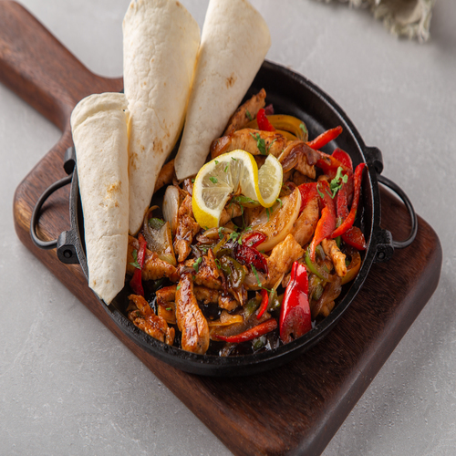 Chicken Fajita - Sliced grilled chicken , mix capsicum & onion, served with tortilla bread & guacamole , sour cream