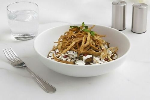 فتة باذنجان - باذنجان مقلي مع بطاطا مكعبات مغطاة بصلصة الطحينة المميزة ، رمان ، سماق ، صنوبر ، خبز التورتيلا المقرمش