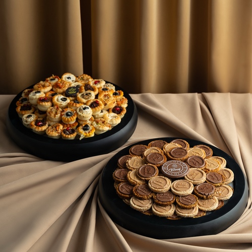 Display of luxury wooden trays with cocoa nuts and mini sandwiches - صينية خشب بتصميم خاص مع مكسرات الكاكاو والكرمل فستق ، لوز ، بندق ، سمسم ٧٠ قطعه مع صينية ميني فطاير ٥ درازن بحشوت مختلفة لبنة زعتر برمان ، حمسة الباذنجان ، مشروم ،زهرة مع البطاط