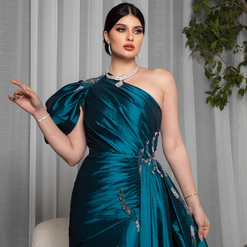 turquoise - A dress made from turquoise taffeta fabric, featuring hand-pleated details and hand-embellished beading, adding a touch of luxury and beauty.