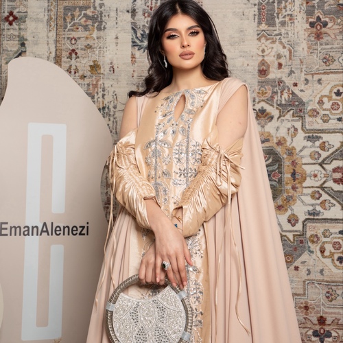 daraa cremy - A creamy-colored “Daraa” made from Kenzo crepe fabric, featuring taffeta details and intricate handwork along its length, adorned with silver chains for an elegant touch.