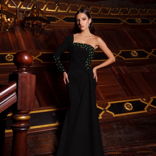 black mix green 2025 - Black crepe dress with pleats at the waist and hip, featuring a one-shoulder sleeve. Embellished with black, silver, and olive green beadwork.