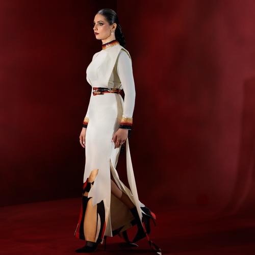 Veloura - A luxurious and elegant gown crafted from premium Spanish crepe, featuring a distinctive design that blends modern sophistication with timeless beauty. Accented with patterned Spanish mikado for an artistic touch, and adorned with refined glass crystal detailing on the neckline and sleeves. Contemporary cuts inspired by the latest fashion trends create a truly exceptional piece for the woman who seeks uniqueness and elegance.