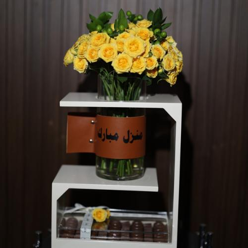 Taraf Stand - It consists of a yellow baby rose, a ball, and green leaves, with a piece of leather and a chocolate box, with a wooden stand Kindly write a sentence on the leather and a sentence on the card in the box below