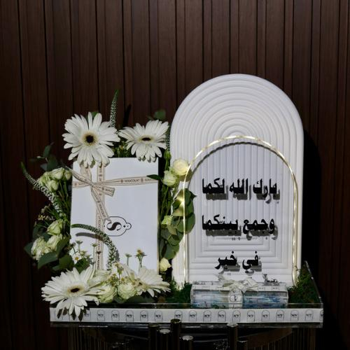 Wateen Tray - It consists of a wooden stand, an acrylic stand with lights, a chocolate box from Socola, a white baby rose, a white Daisy flower, green leaves, and some small spring flowers. 
 Kindly write the sentence on the card in the box below