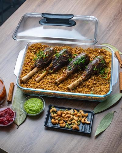 Madfoun with  Meat - مدفون لحم الموزات، طبق تراثي فاخر يتضمن قطع لحم موزات تُقدم فوق طبقة من أرز بسمتي معطر بالزعفران والبهارات. يُطهى الأرز في مرق اللحم الغني، و حشو مكون من الحمص و الزبيب و البصل المكرمل يكفي من 6 الى 8 أشخاص