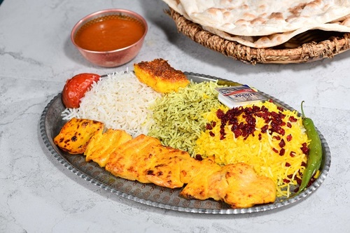 Shish Tawook with Rice - Pieces of fresh chicken without bone with mix rice the iranian dressing in a manner yas and served with dqos and surfs yas with warm bread.