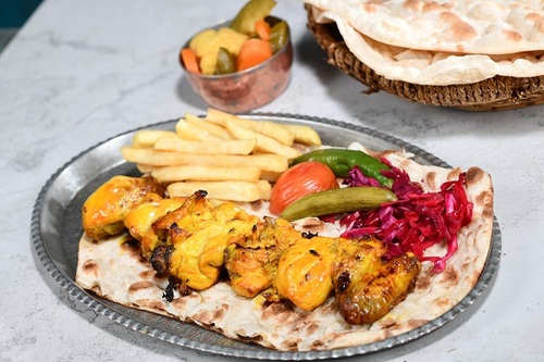 Kabab Jojh - Pieces of fresh chicken with bone mixed with saffron with mix rice the iranian dressing and served with daqos with warm bread.