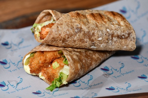 روبيان بروتين سندوش - Crispy breaded shrimp served on protein tortilla bread with tangy tartar sauce fresh pickles and lettuce for a satisfying and nutritious meal