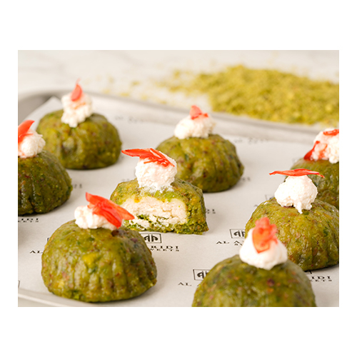 Mafrooka Pistacio - A thick layer of Pistacio mixed with sugar syrup, topped with cream and roasted nuts.