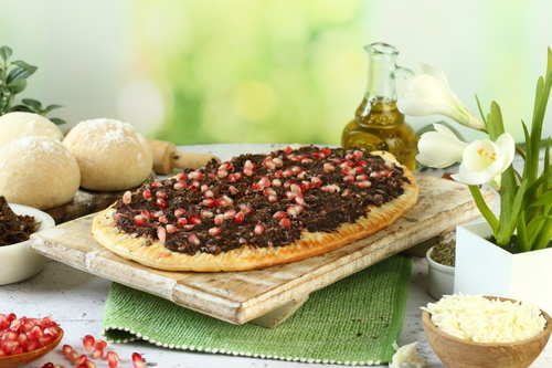 Mah'shiah spinach with cheese - Lebanese dough stuffed with cheese, covered with spinach, pine seeds and  pomegranate seeds.