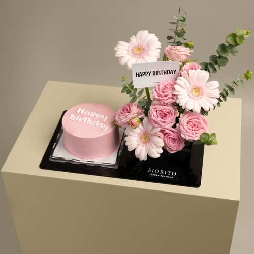 Pink Joy - An acrylic tray filled with gerbera, baby roses, and eucalyptus with a cake. A great gift to celebrate birthdays and bring joyfulness. Note: Cake writing is customizable.