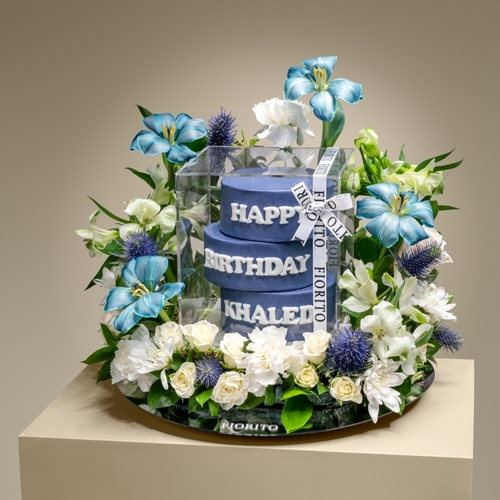 Blue Charm - A reflective glass tray with tulips, baby roses, and alstroemeria with a cake. Adds an elegant and charming touch to their birthday. Note: cake writing is customizable.