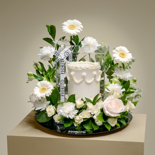 Honor and Delight - A reflective glass tray with baby roses, gerberas, hypericum, and a delightful cake. Suitable for cheerful festive occasions and putting a smile on faces.