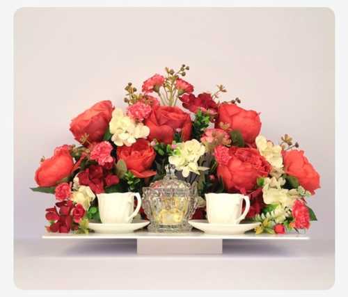 A tray containing chocolate coffee cups decorated with artificial flowers