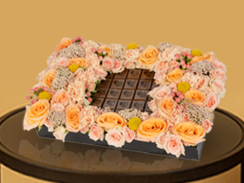 Dora5 - A distinctive acrylic tray with a beautiful arrangement of roses from a Dutch flower mixture that suits all tastes, with the addition of delicious pieces of chocolate with Belgian ingredients . Size: 25/40 cm