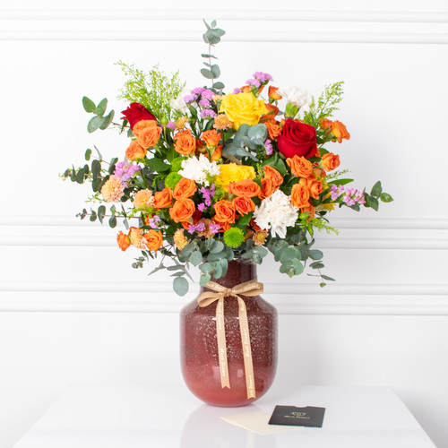 Coco - Roses, baby roses, chrysanthemums, and carnations arranged beautifully in a vase with a card.