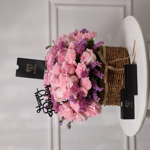 Antoflora - A basket filled with roses, carnations, chrysanthemums and purple statices along with chocolates.