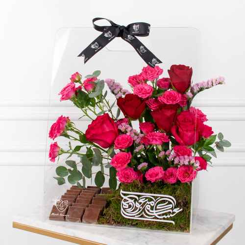 Eklil Bouquet - A refined arrangement featuring red roses and pink baby roses, accented with limonium and eucalyptus, accompanied by delicious chocolates in an elegant transparent box.