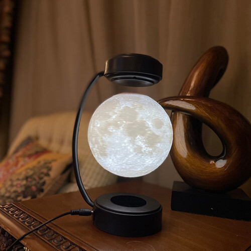 Moon Lamp - Black Levitating Moon lamp with three shade (white/yellow/orange) spinning. A button to change between the shades and turn ON/OFF. Could be left spinning on day and night with lights ON/OFF Hight :26 cm. Moon:D: 14cm base: hight : 4 cm