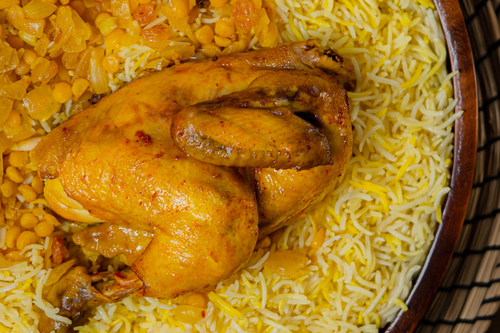 Machboos chicken - Half a chicken with machboos rice served with hasho, maabooch
  and daqous.