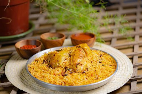 Biryani chiken - Half a chiken with marinated biryani rice served with biryani
  yogurt sause, daqous and maabooch.