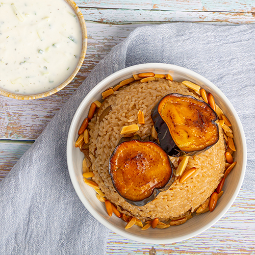 Eggplant Maqluba (No Meat) - Rice cooked with eggplants garnished with nuts served with cucumber yogurt salad.